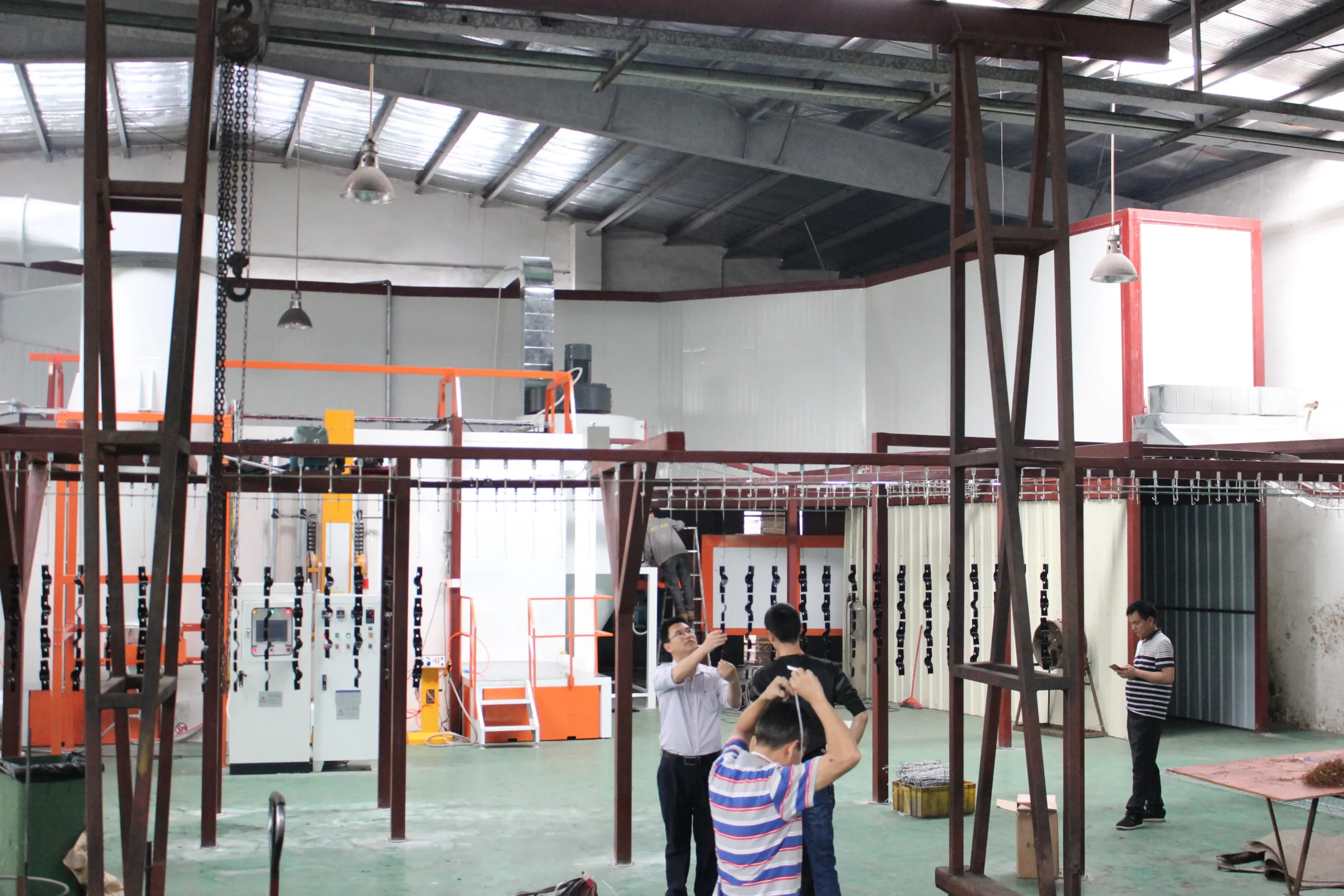 Equipment assembly line with technicians assembling coating line components