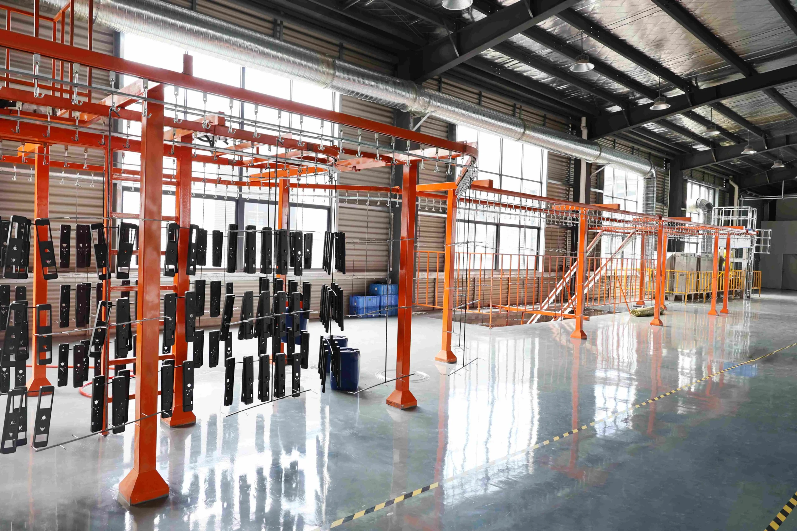 Assembly workshop with technicians assembling powder coating equipment